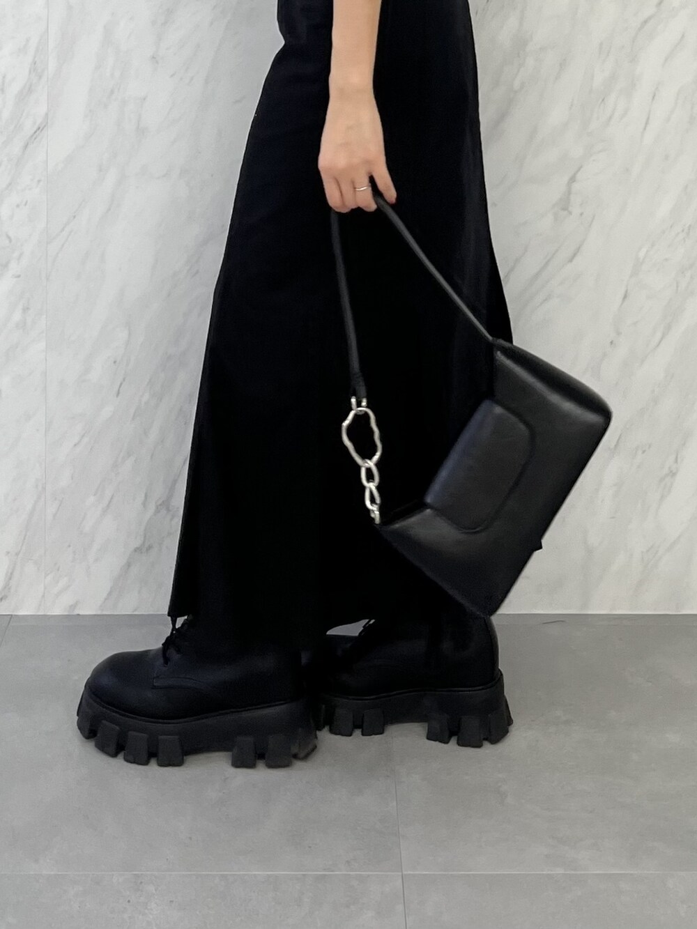 ブラック系のブーツ、ブラック系のスカート、イエロー系のニット/セーターを着用したレディースの春コーディネートの8枚目の写真