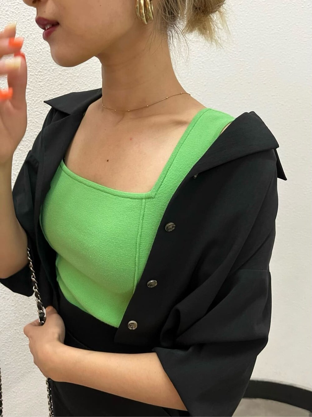 ブラック系のシャツ/ブラウス、ブラック系のショルダーバッグ、グリーン系のタンクトップを着用したレディースの春コーディネートの4枚目の写真