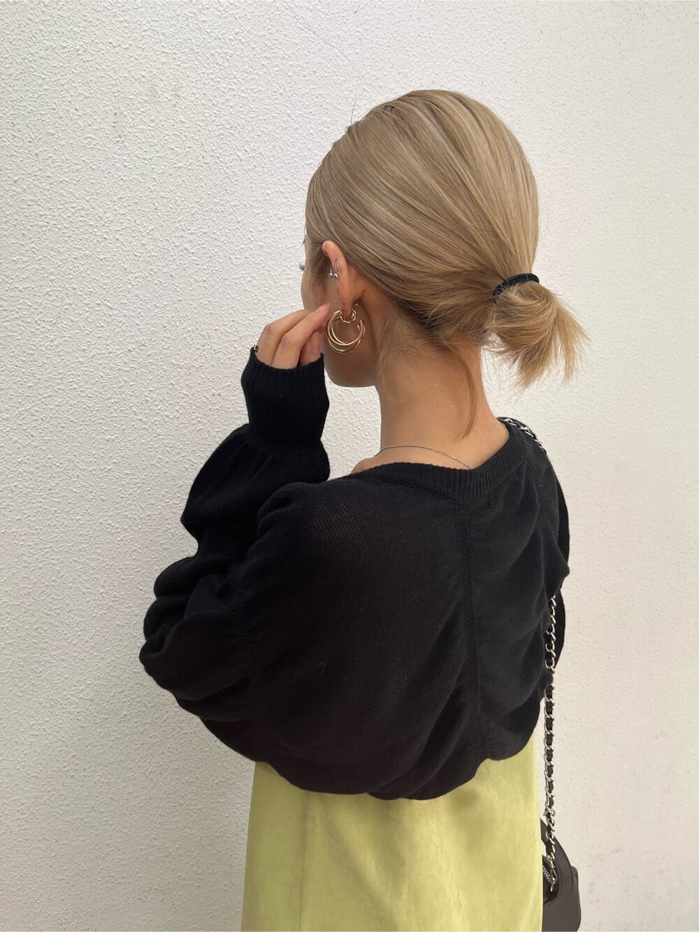 ブラック系のブーツ、ブラック系のニット/セーター、イエロー系のワンピースを着用したレディースの春コーディネートの6枚目の写真