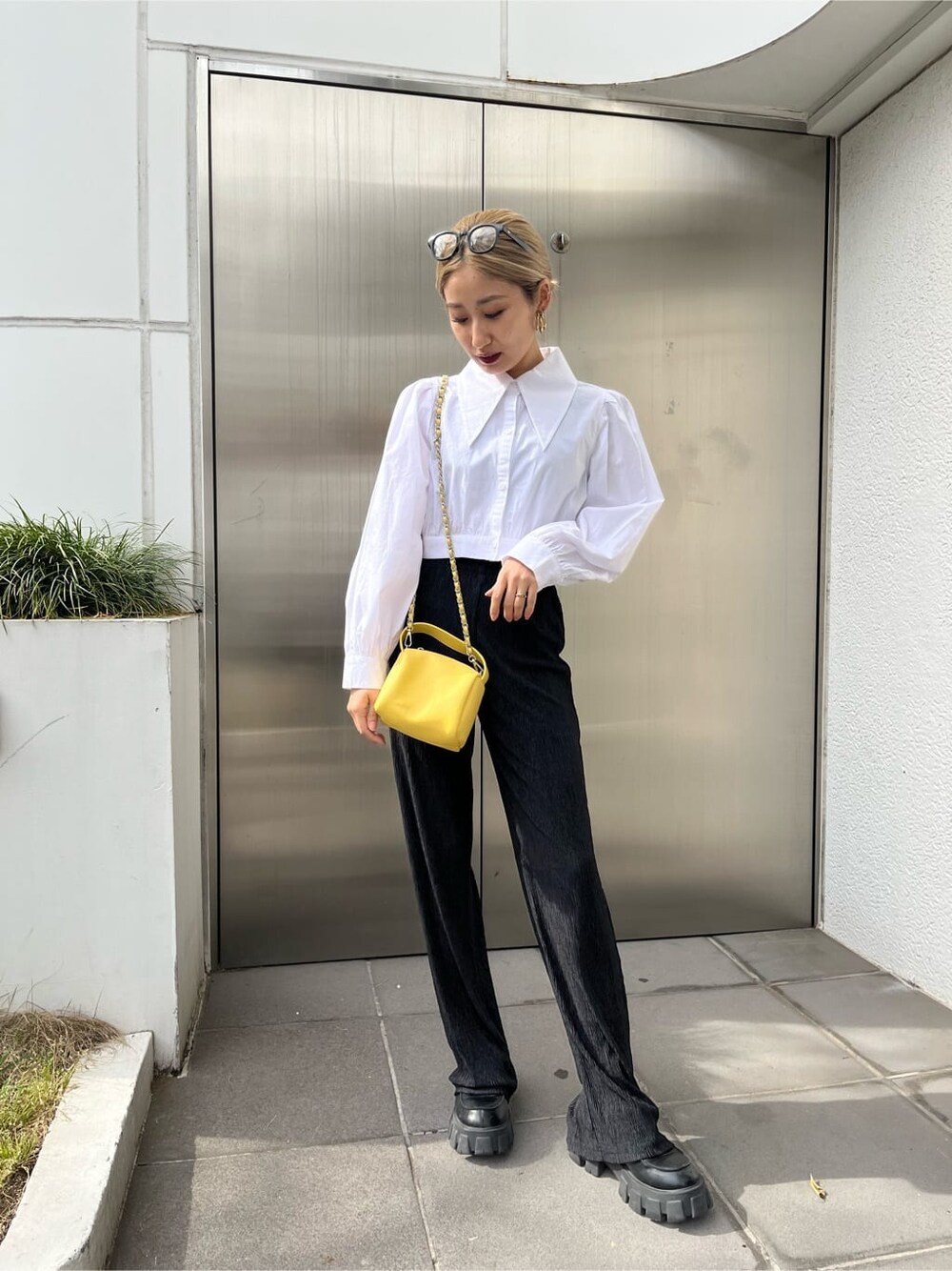 ブラック系のその他パンツ、イエロー系のショルダーバッグ、ホワイト系のシャツ/ブラウスを着用したレディースの春コーディネートの3枚目の写真