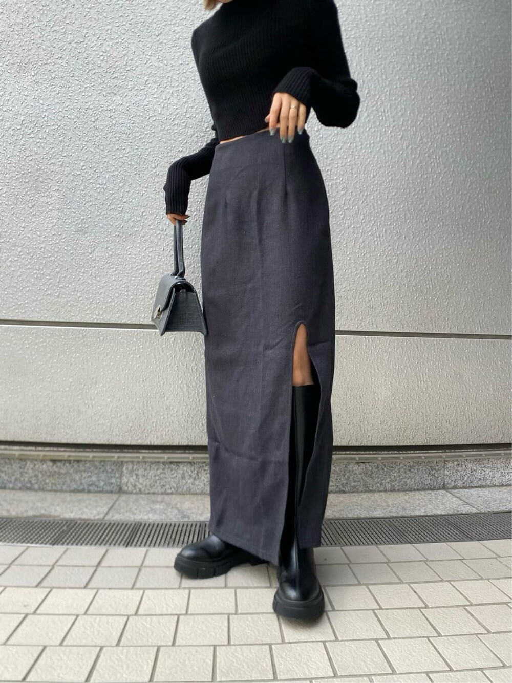 ブラック系のニット/セーター、ブラック系のブーツ、ブラック系のハンドバッグを着用したレディースの冬コーディネートの6枚目の写真