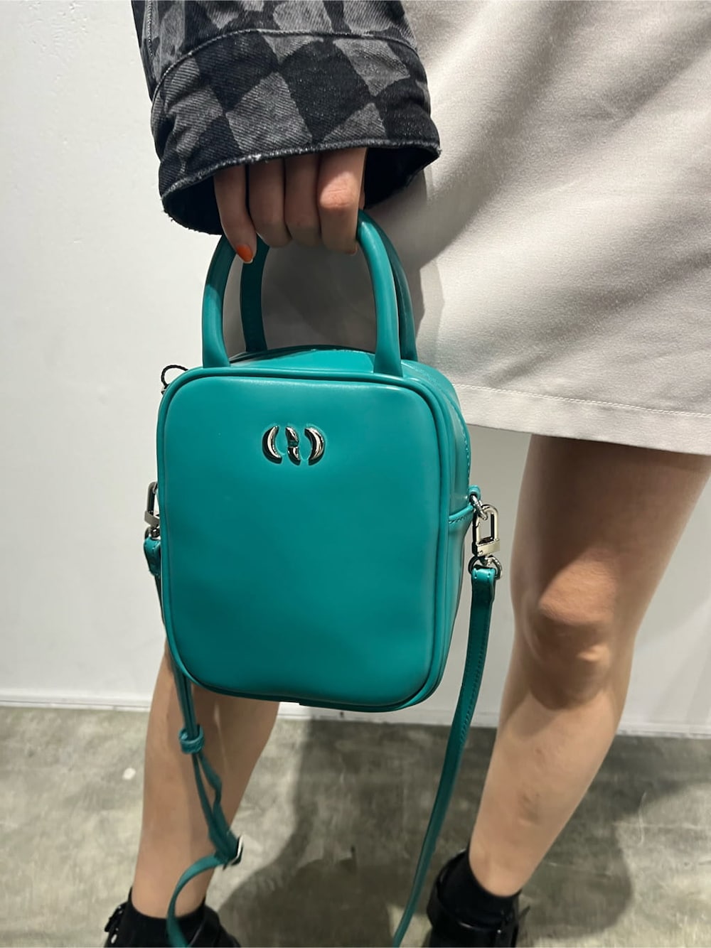 その他のデニムジャケット、ホワイト系のスカート、ブルー系のショルダーバッグを着用したレディースの春コーディネートの7枚目の写真