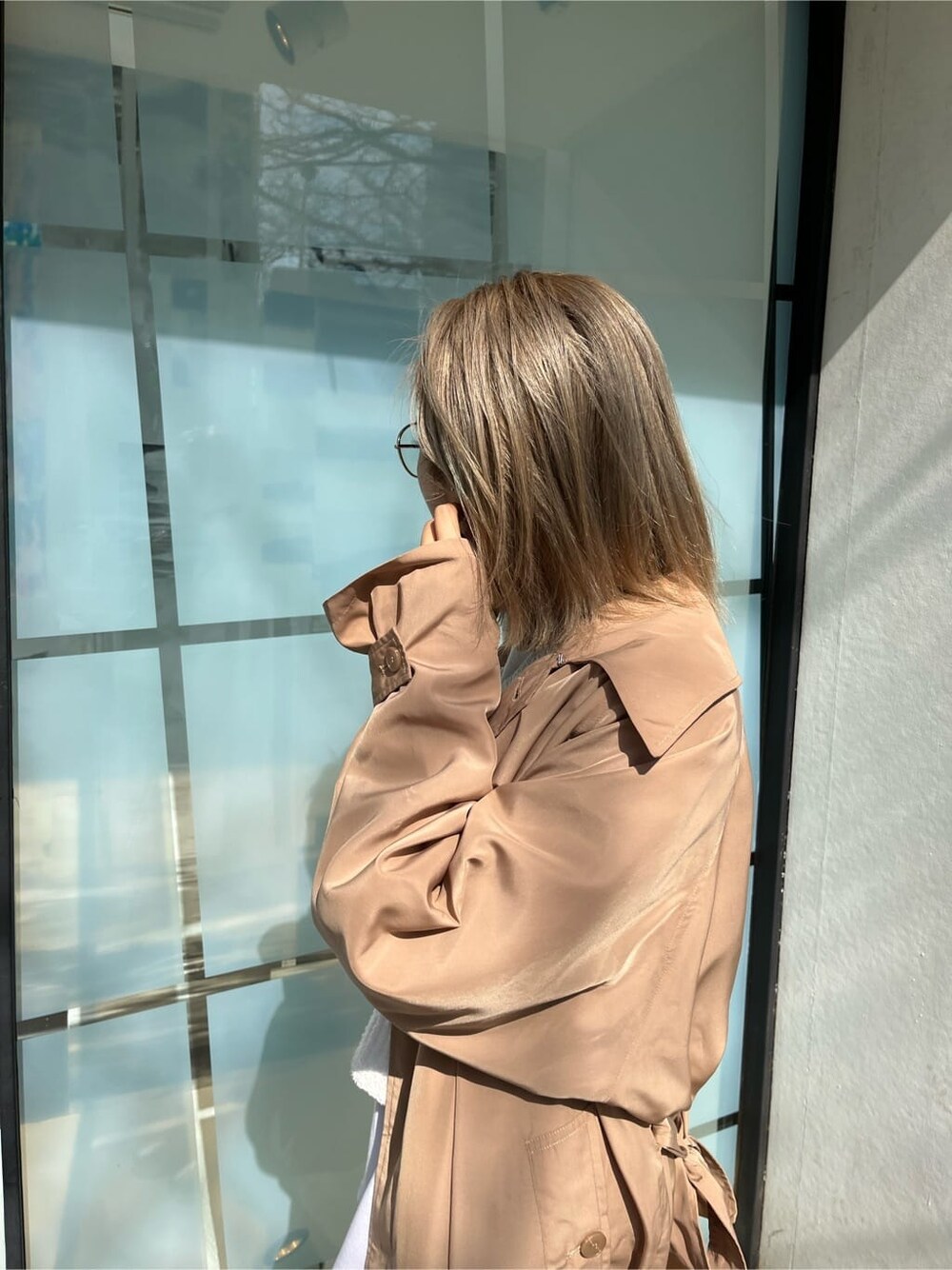 ブラック系のブーツ、ホワイト系のTシャツ/カットソー、ベージュ系のトレンチコートを着用したレディースの春コーディネートの5枚目の写真