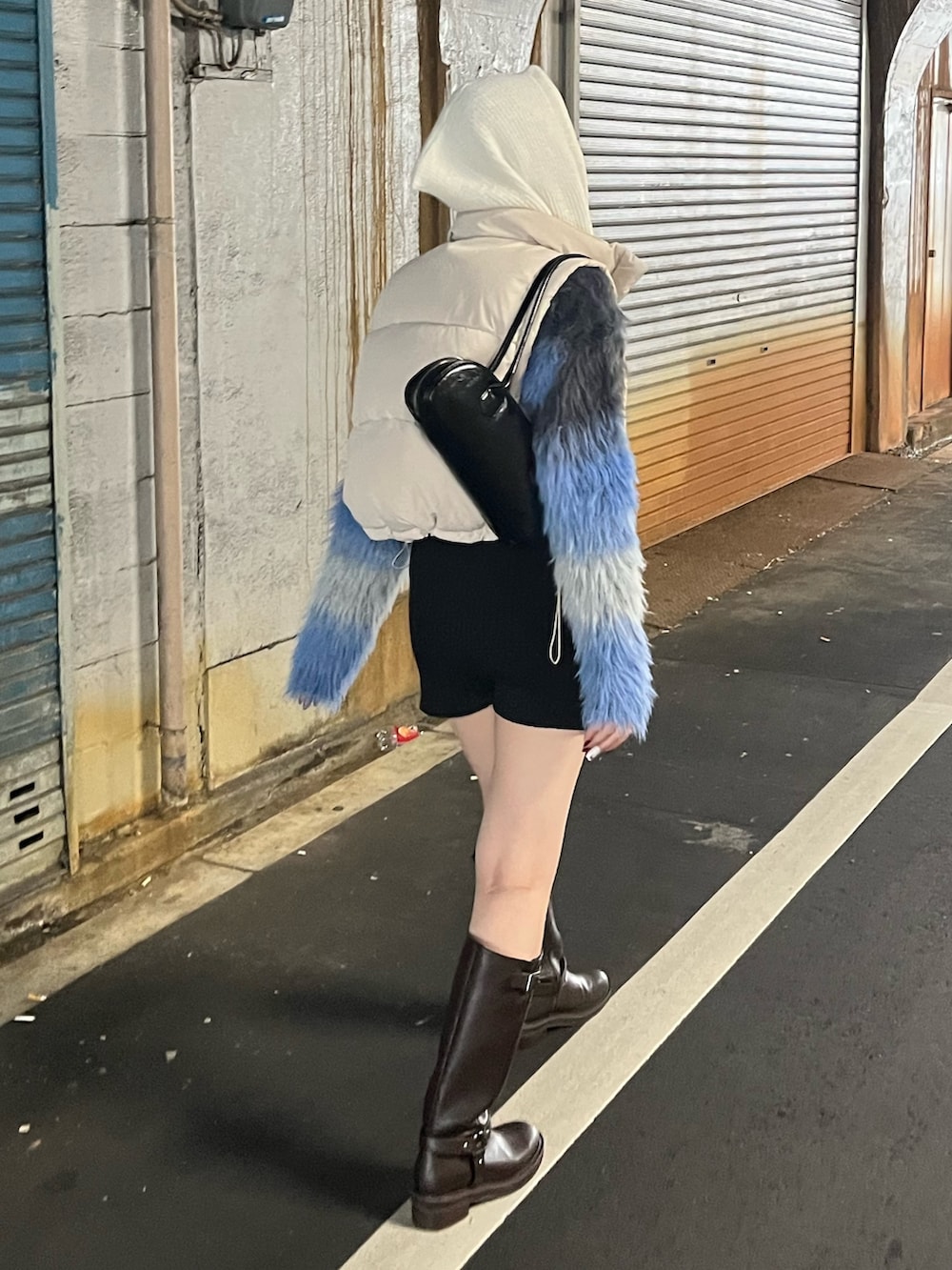 グレー系のニット/セーター、ホワイト系のブルゾン、ブラック系のブーツを着用したレディースの秋コーディネートの2枚目の写真