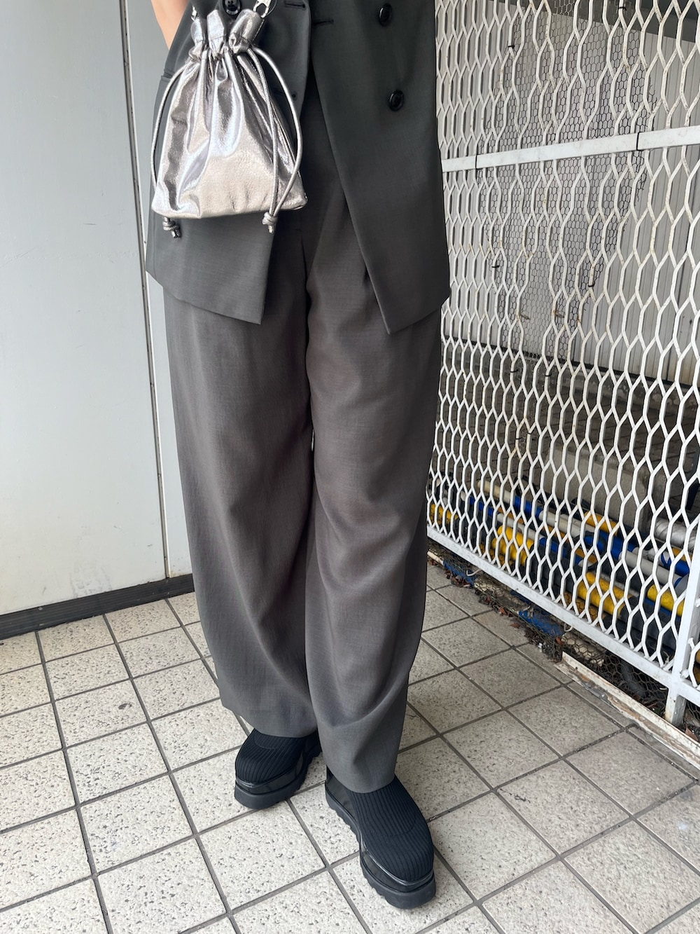 ブルー系のニット/セーター、グレー系のベスト、グレー系のその他パンツを着用したレディースの春コーディネートの4枚目の写真