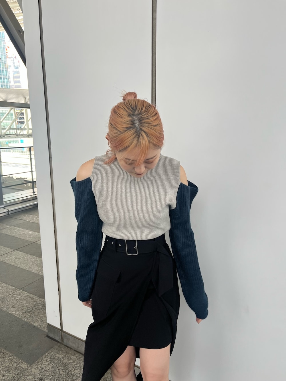 ブラック系のスカート、ブラック系のブーツ、グレー系のニット/セーターを着用したレディースの秋コーディネートの4枚目の写真