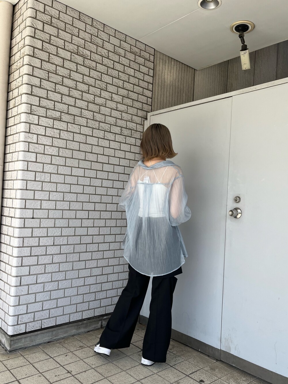 ブルー系のシャツ/ブラウス、ブラック系のスラックス、ホワイト系のTシャツ/カットソーを着用したレディースの春コーディネートの3枚目の写真