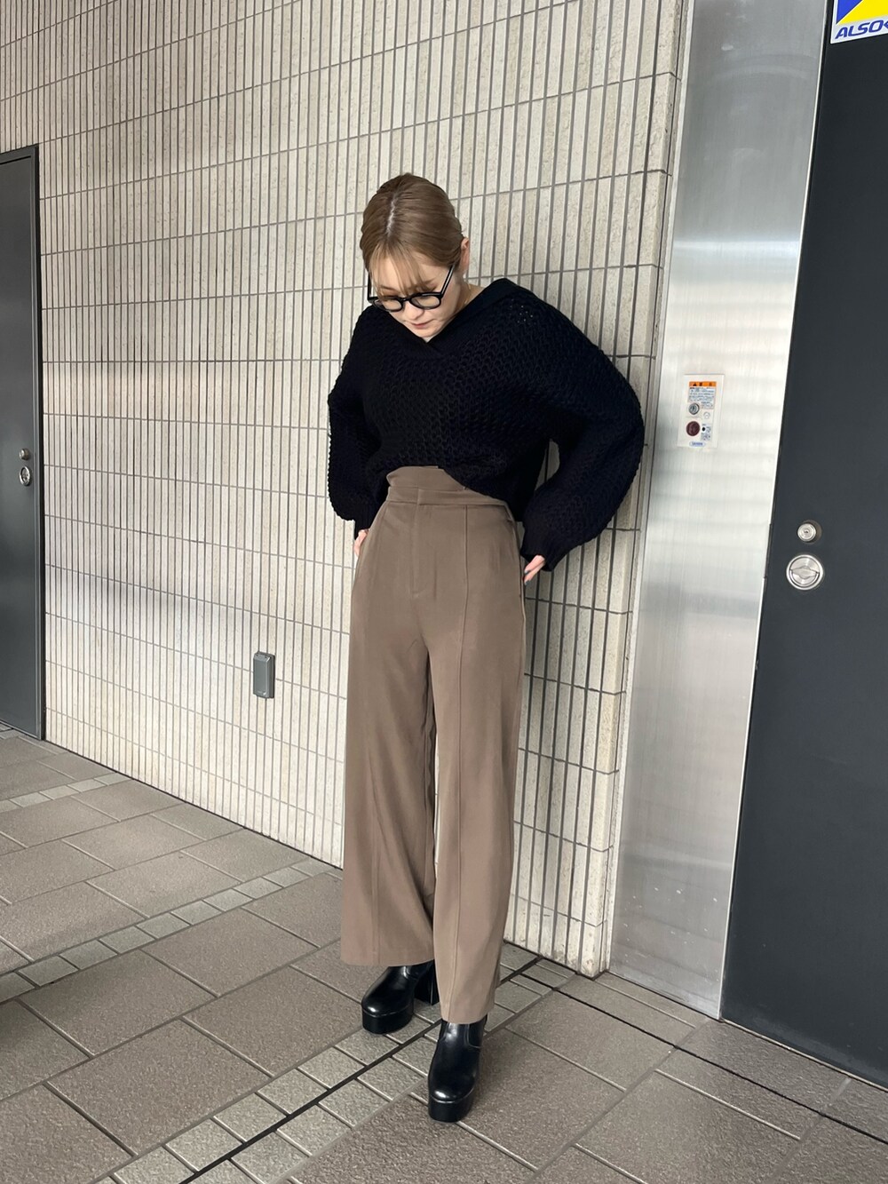 ブラック系のニット/セーター、ベージュ系のスラックス、ブラック系のブーツを着用したレディースの冬コーディネートの5枚目の写真