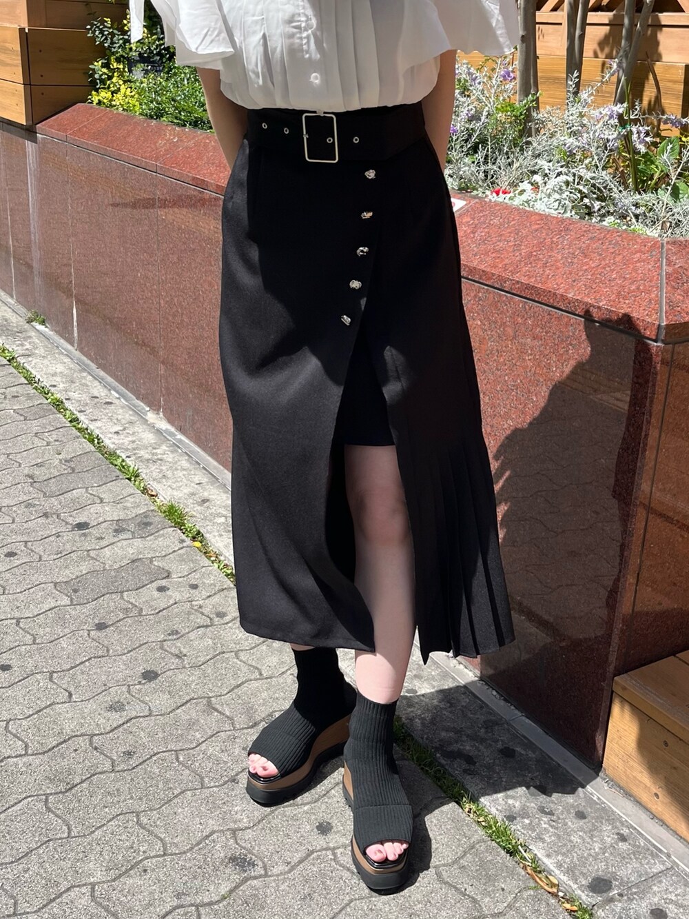 ホワイト系のシャツ/ブラウス、ブラック系のスカート、ブラック系のブーツを着用したレディースの春コーディネートの4枚目の写真