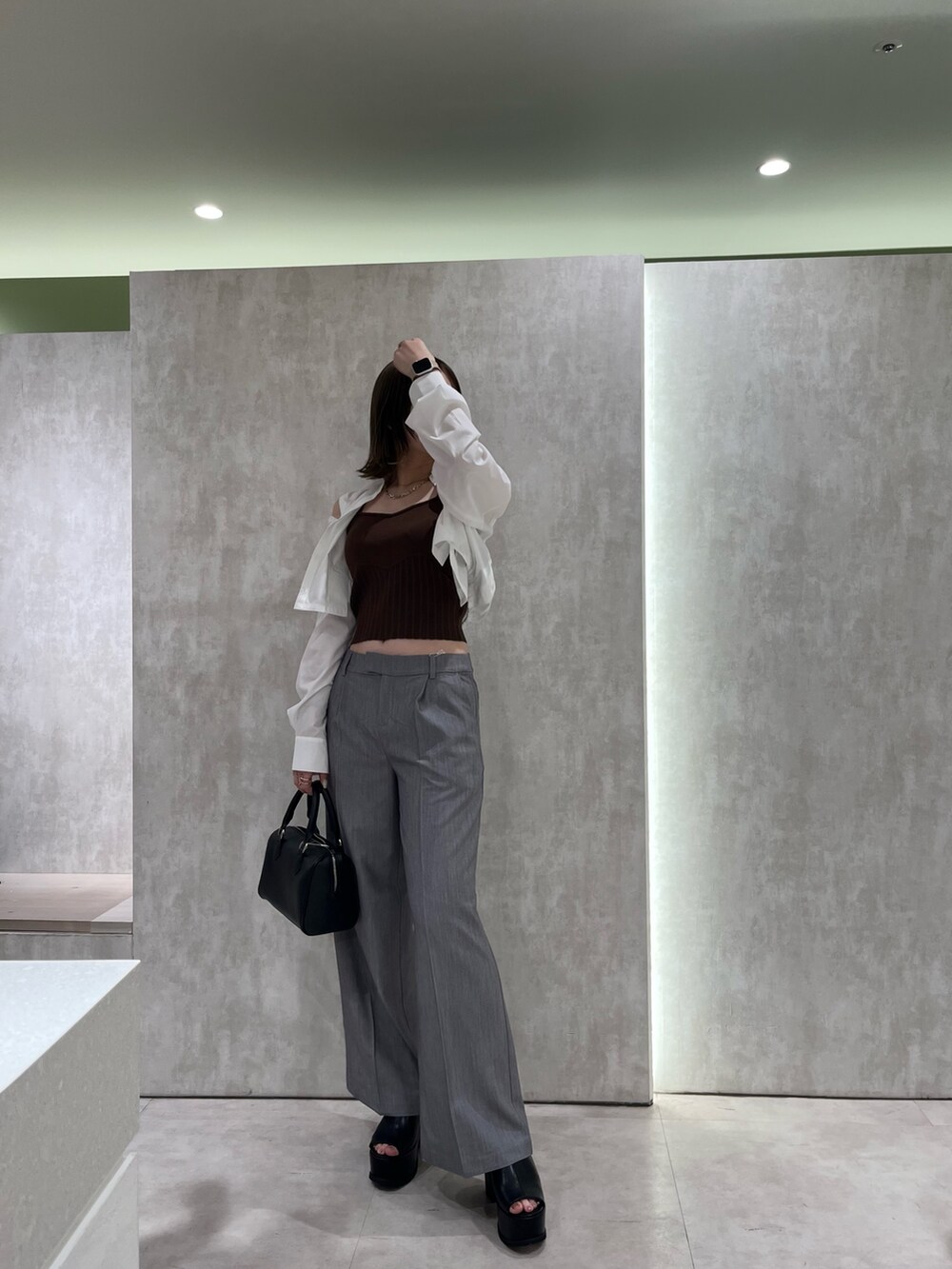 ブラウン系のニット/セーター、ホワイト系のシャツ/ブラウス、ブラック系のサンダルを着用したレディースの春コーディネートの6枚目の写真