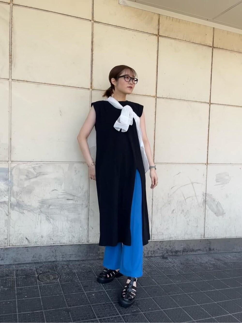 ホワイト系のシャツ/ブラウス、ブルー系のスラックス、ブラック系のサンダルを着用したレディースの夏コーディネートの6枚目の写真