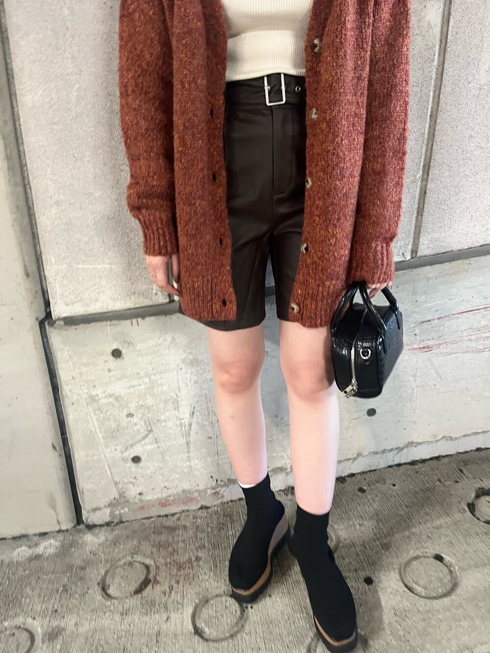 オレンジ系のカーディガン/ボレロ、ホワイト系のニット/セーター、ブラウン系のその他パンツを着用したレディースの秋コーディネートの5枚目の写真