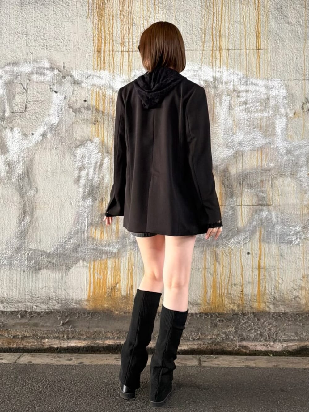 ブラック系のテーラードジャケット、ブラック系のパーカー、ホワイト系のキャミソールを着用したレディースの春コーディネートの5枚目の写真