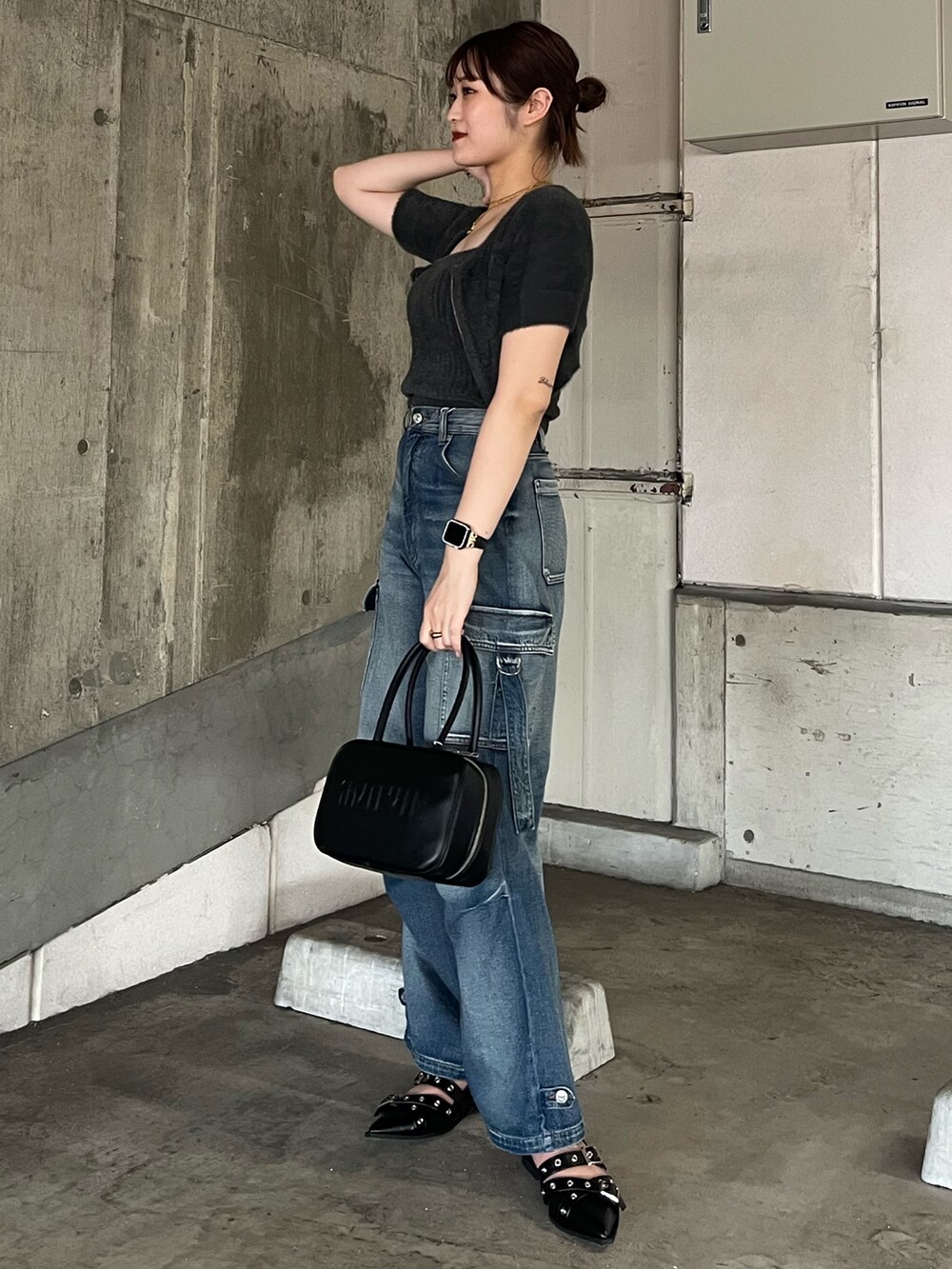 グレー系のニット/セーター、ブルー系のデニムパンツ、ブラック系のパンプスを着用したレディースの秋コーディネートの2枚目の写真