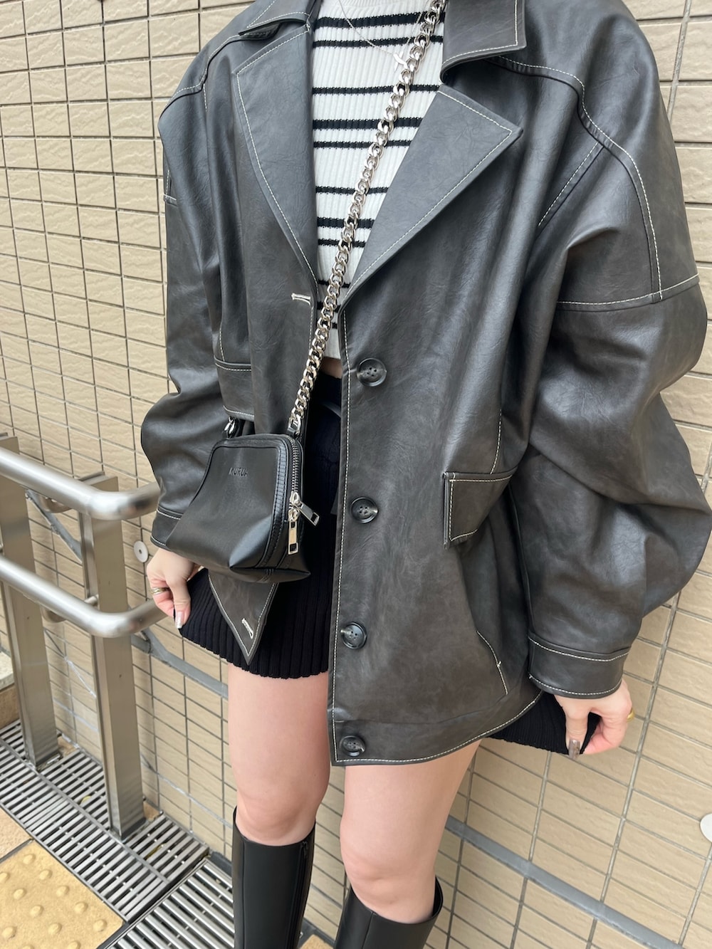 グレー系のブルゾン、その他のニット/セーター、ブラック系のハンドバッグを着用したレディースの冬コーディネートの2枚目の写真