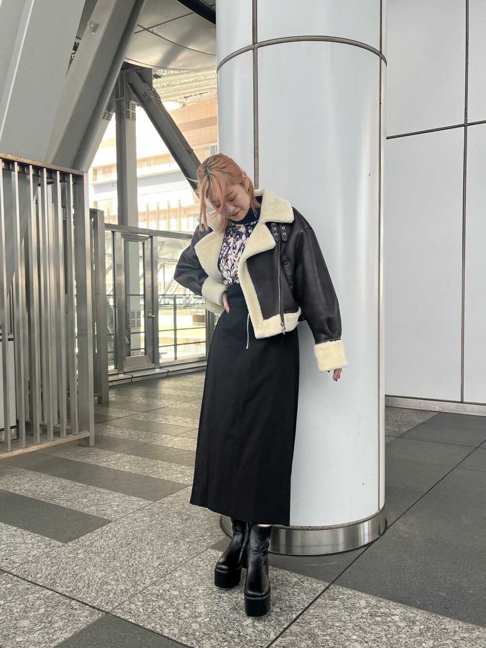 パープル系のニット/セーター、ブラック系のスカート、ブラック系のブーツを着用したレディースの秋コーディネートの2枚目の写真