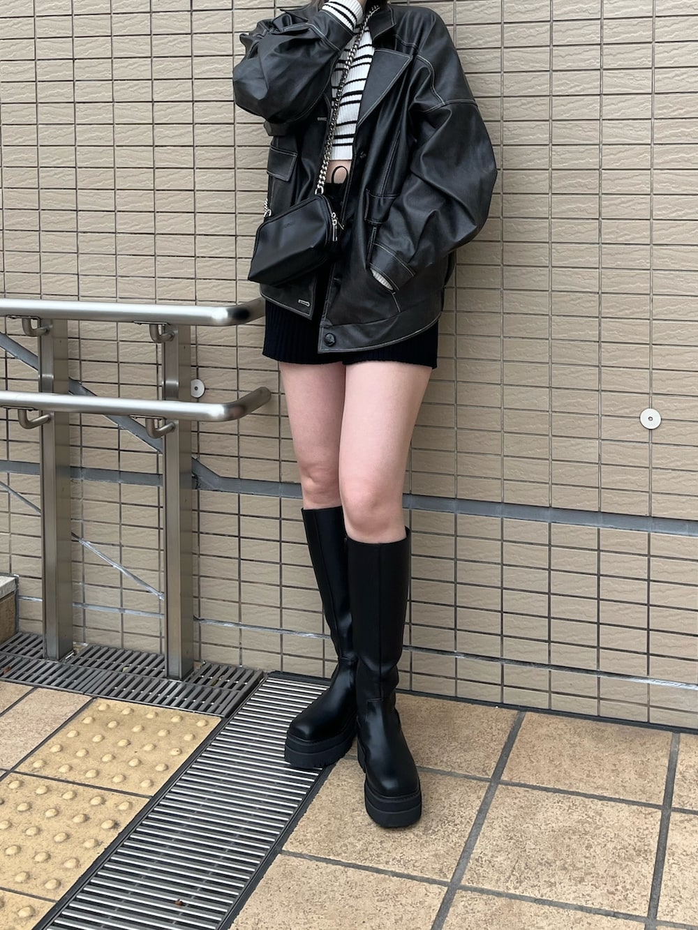 グレー系のブルゾン、その他のニット/セーター、ブラック系のハンドバッグを着用したレディースの冬コーディネートの4枚目の写真