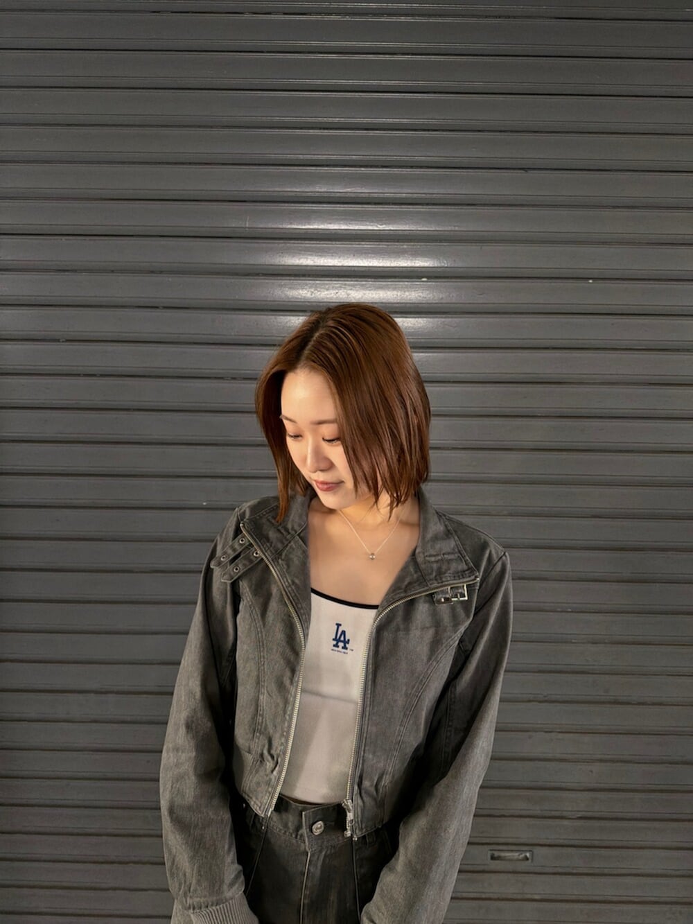 ホワイト系のキャミソール、ブラック系のブーツ、グレー系のその他パンツを着用したレディースの春コーディネートの6枚目の写真