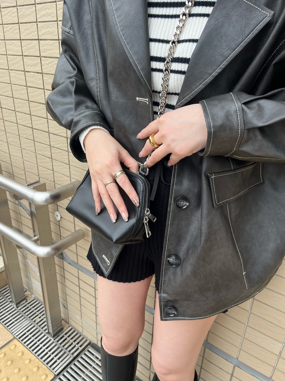 グレー系のブルゾン、その他のニット/セーター、ブラック系のハンドバッグを着用したレディースの冬コーディネートの5枚目の写真