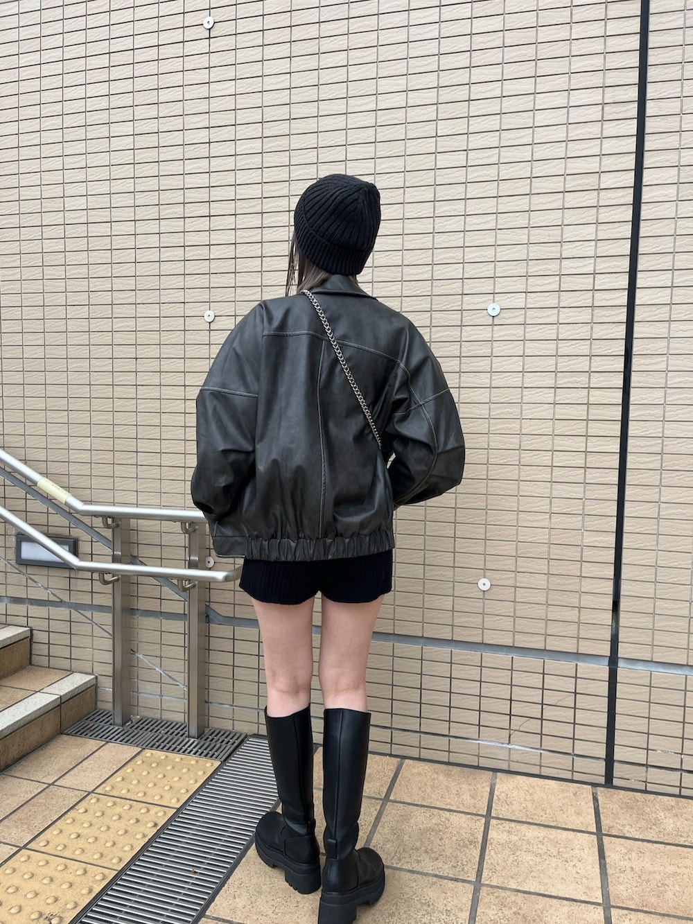 グレー系のブルゾン、その他のニット/セーター、ブラック系のハンドバッグを着用したレディースの冬コーディネートの3枚目の写真