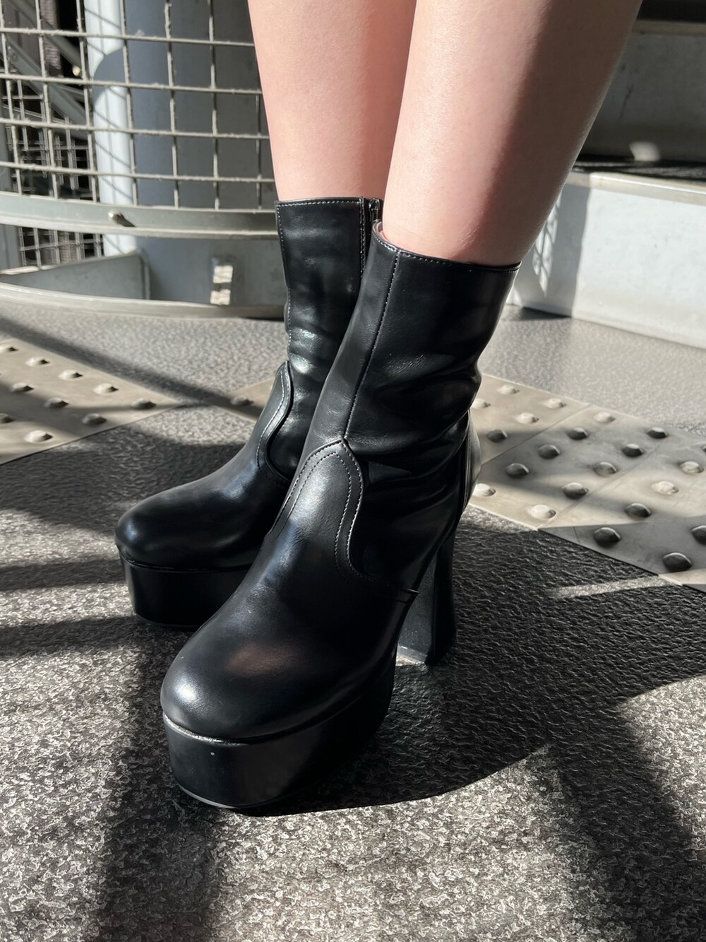 グレー系のワンピース、ブラック系のブーツを着用したレディースの冬コーディネートの8枚目の写真