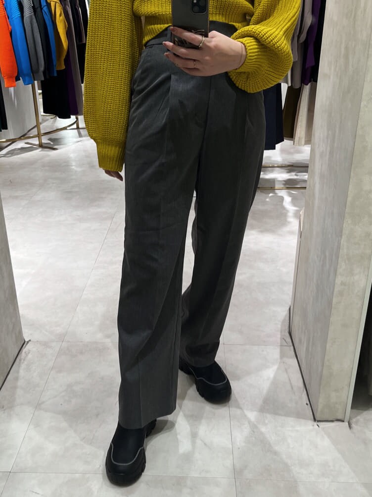 イエロー系のニット/セーター、ブラック系のブーツ、グレー系のスラックスを着用したレディースの秋コーディネートの5枚目の写真