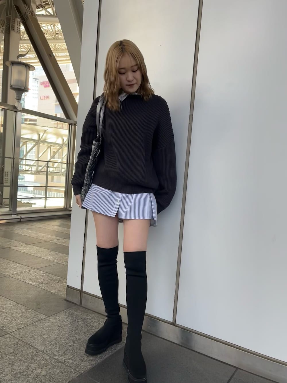 ブラック系のワンピース、グレー系のニット/セーター、グレー系のトートバッグを着用したレディースの冬コーディネートの2枚目の写真