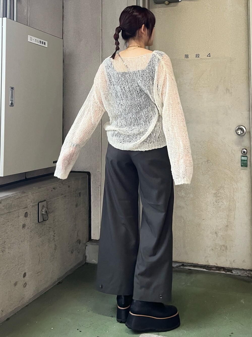 ホワイト系のニット/セーター、グレー系のその他パンツ、ブラック系のブーツを着用したレディースの秋コーディネートの5枚目の写真