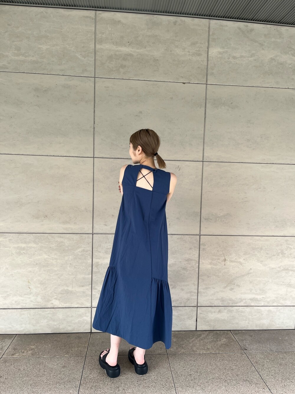ブルー系のワンピース、ホワイト系のシャツ/ブラウス、ブラック系のサンダルを着用したレディースの夏コーディネートの2枚目の写真