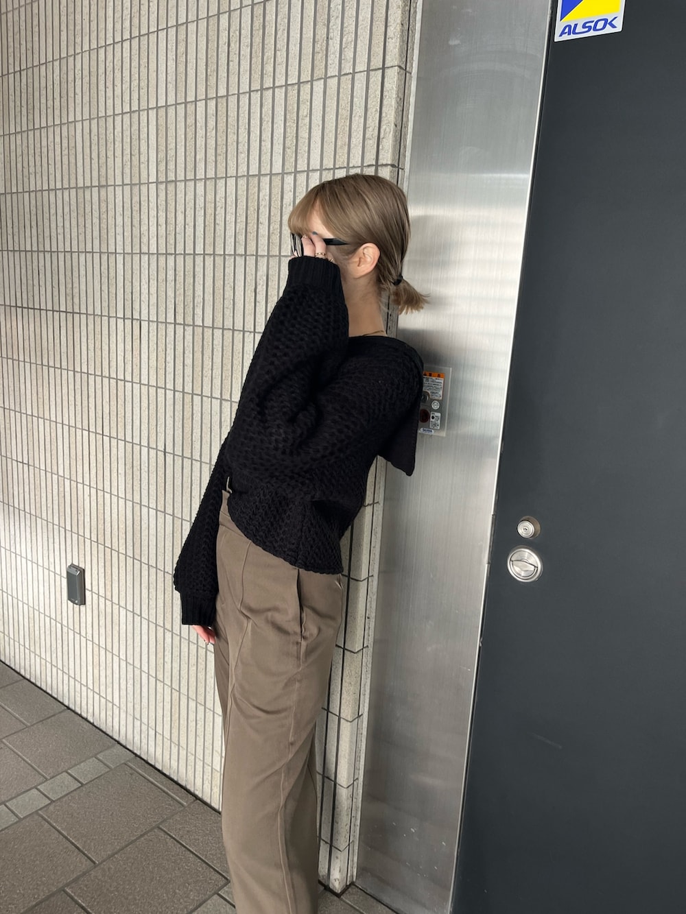 ブラック系のニット/セーター、ベージュ系のスラックス、ブラック系のブーツを着用したレディースの冬コーディネートの4枚目の写真