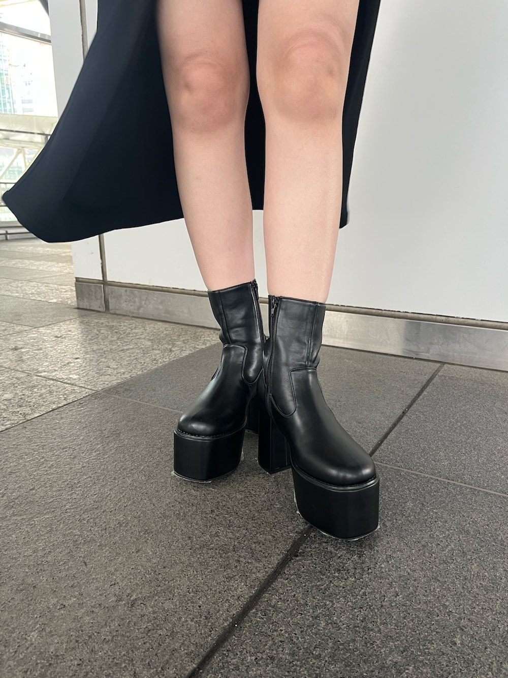 ブラック系のスカート、ブラック系のブーツ、グレー系のニット/セーターを着用したレディースの秋コーディネートの3枚目の写真