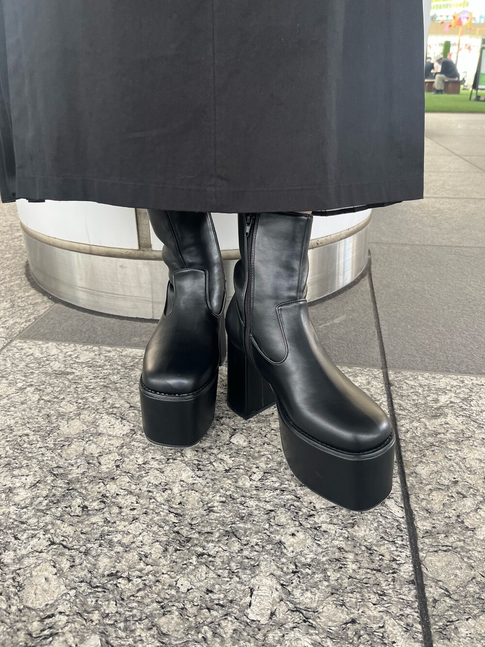 パープル系のニット/セーター、ブラック系のスカート、ブラック系のブーツを着用したレディースの秋コーディネートの7枚目の写真