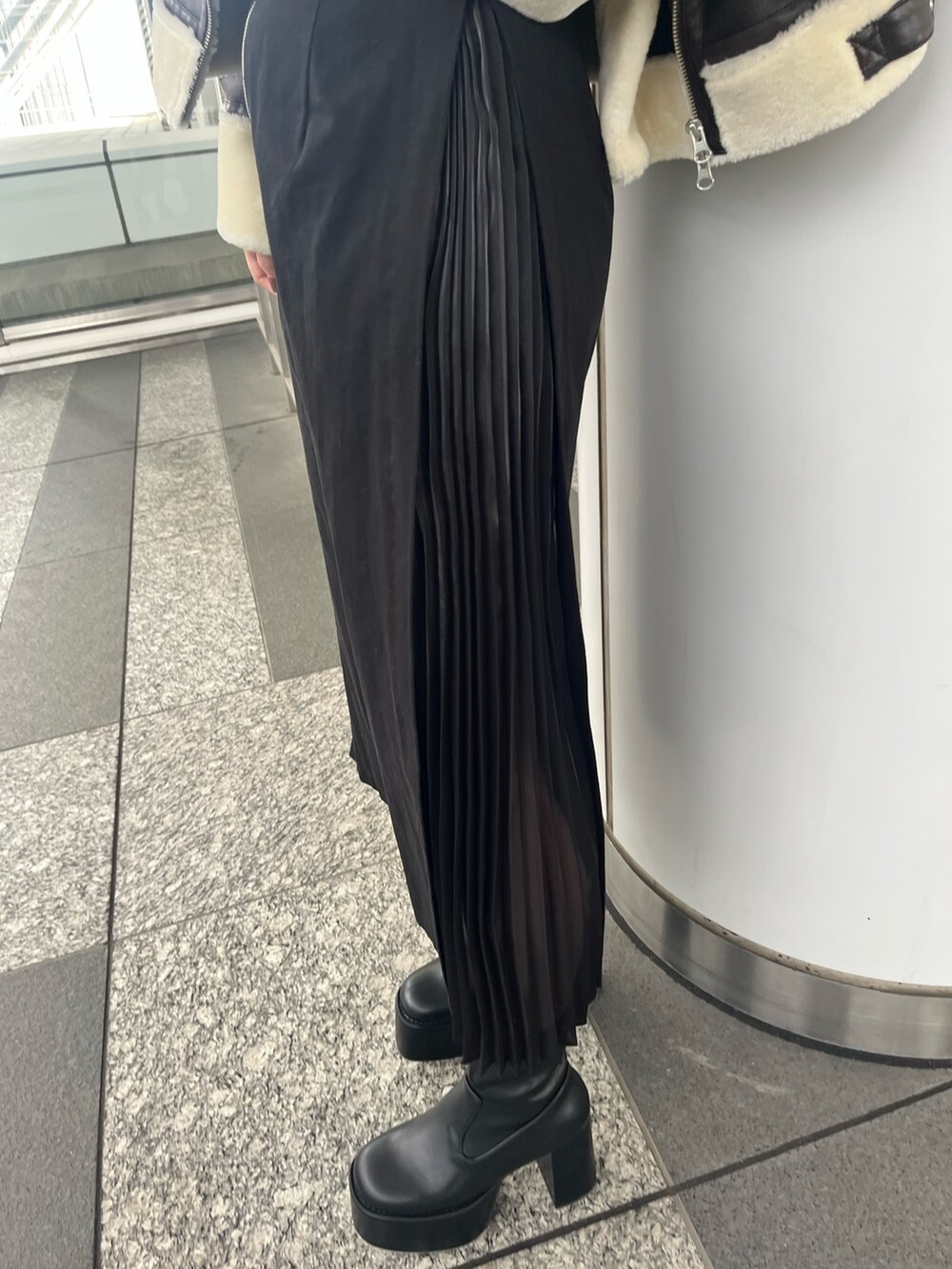 パープル系のニット/セーター、ブラック系のスカート、ブラック系のブーツを着用したレディースの秋コーディネートの8枚目の写真