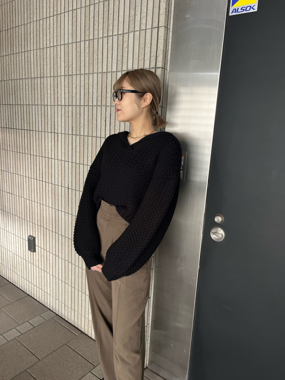 ブラック系のニット/セーター、ベージュ系のスラックス、ブラック系のブーツを着用したレディースの冬コーディネートの2枚目の写真