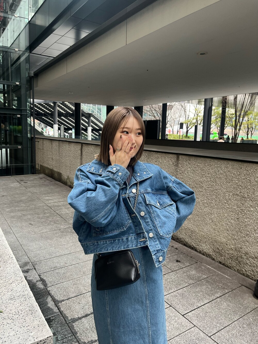 ブルー系のデニムジャケット、ブルー系のワンピース、ブラック系のブーツを着用したレディースの冬コーディネートの5枚目の写真