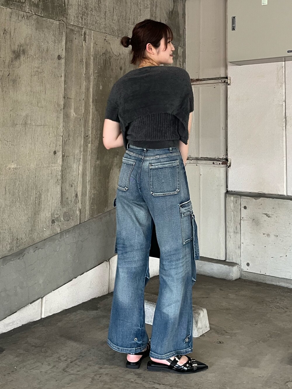 グレー系のニット/セーター、ブルー系のデニムパンツ、ブラック系のパンプスを着用したレディースの秋コーディネートの5枚目の写真