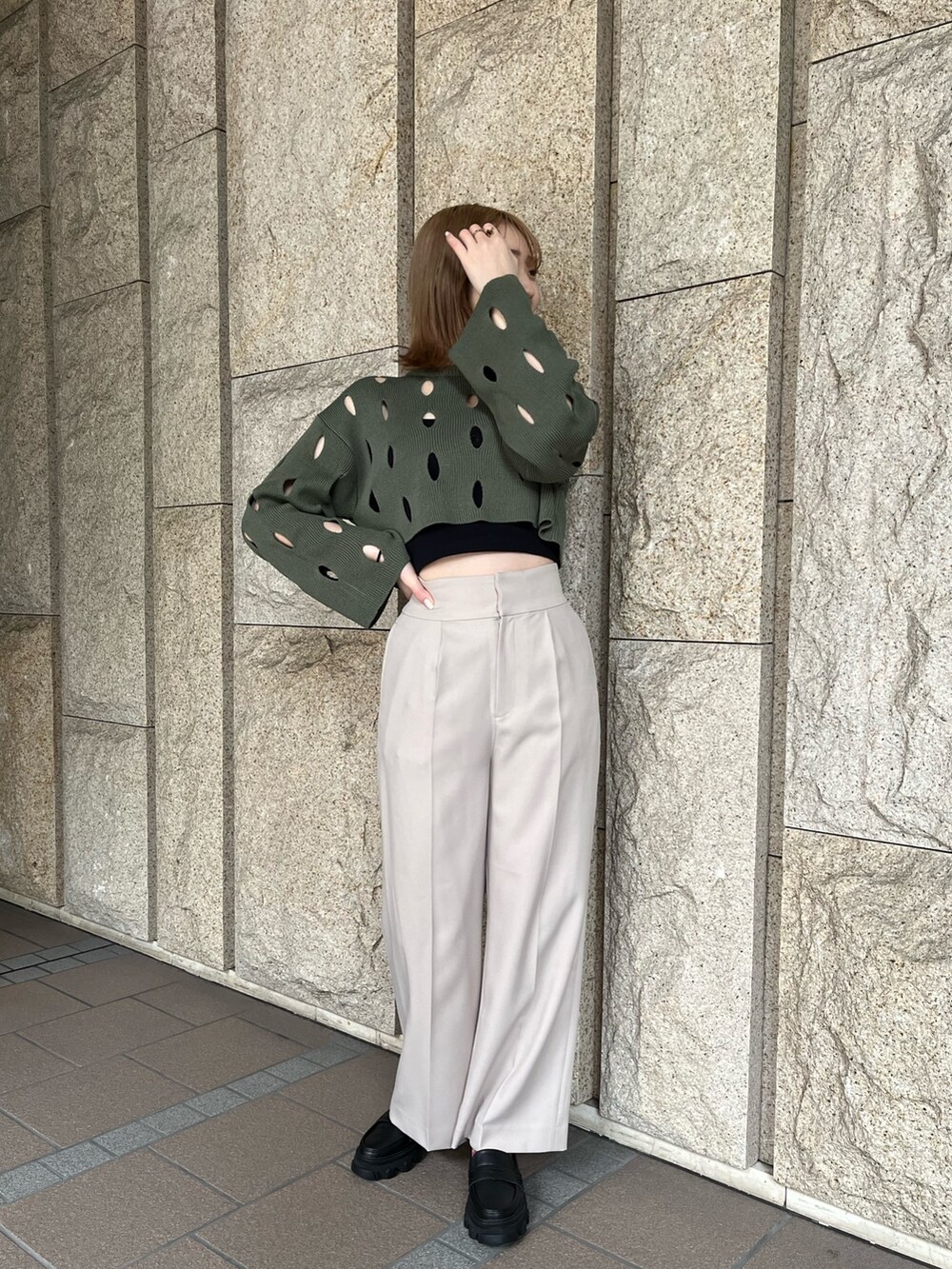 ブラック系のローファー、ベージュ系のスラックス、グリーン系のニット/セーターを着用したレディースの冬コーディネートの5枚目の写真