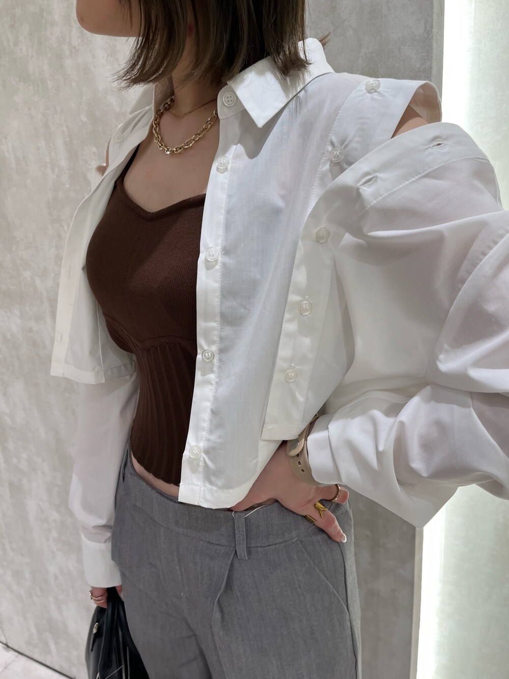 ブラウン系のニット/セーター、ホワイト系のシャツ/ブラウス、ブラック系のサンダルを着用したレディースの春コーディネートの4枚目の写真