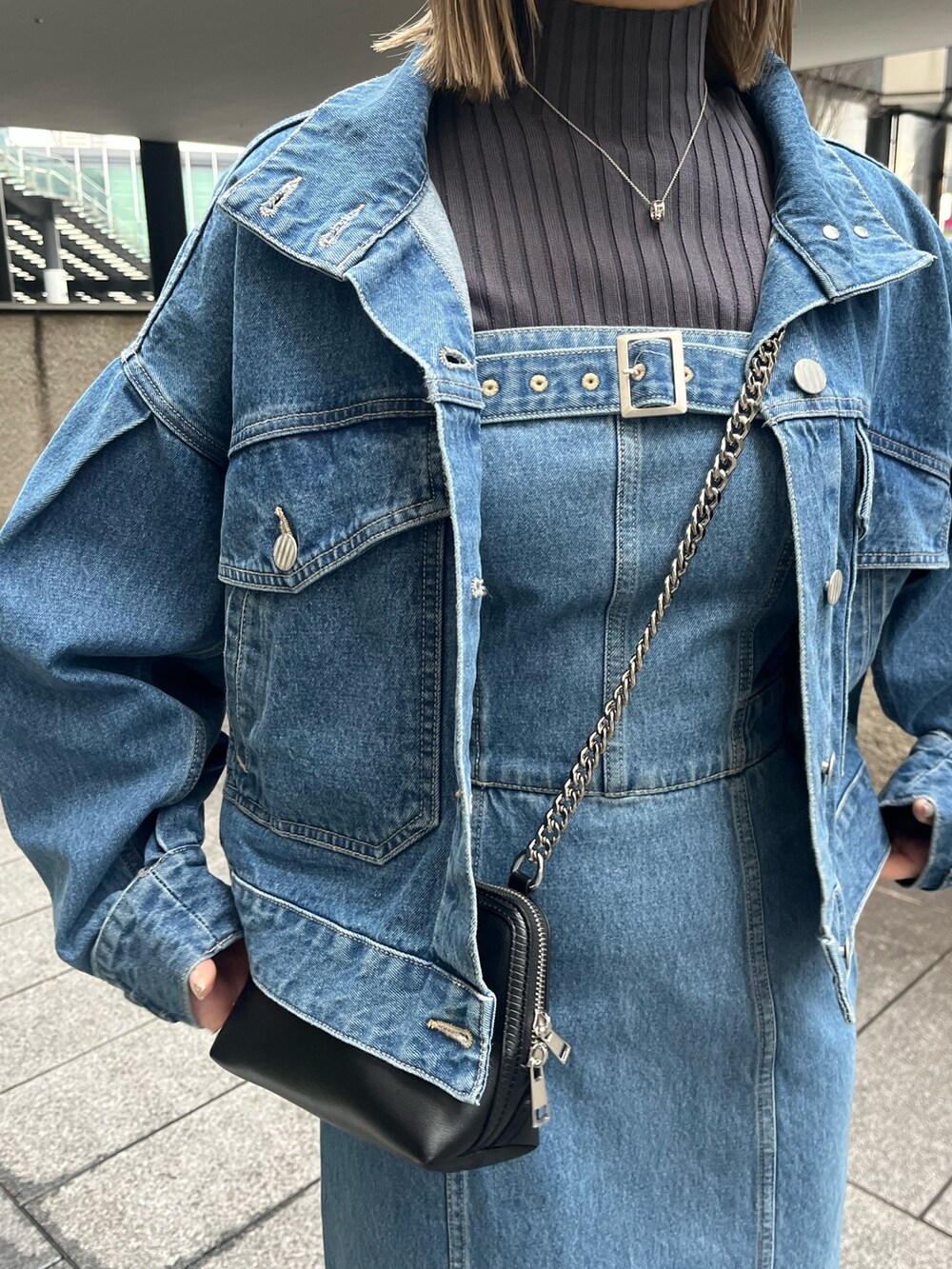 ブルー系のデニムジャケット、ブルー系のワンピース、ブラック系のブーツを着用したレディースの冬コーディネートの6枚目の写真