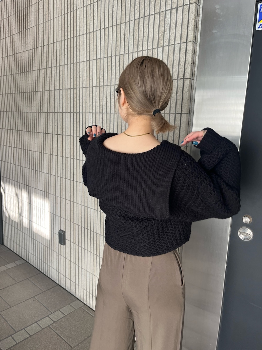 ブラック系のニット/セーター、ベージュ系のスラックス、ブラック系のブーツを着用したレディースの冬コーディネートの3枚目の写真