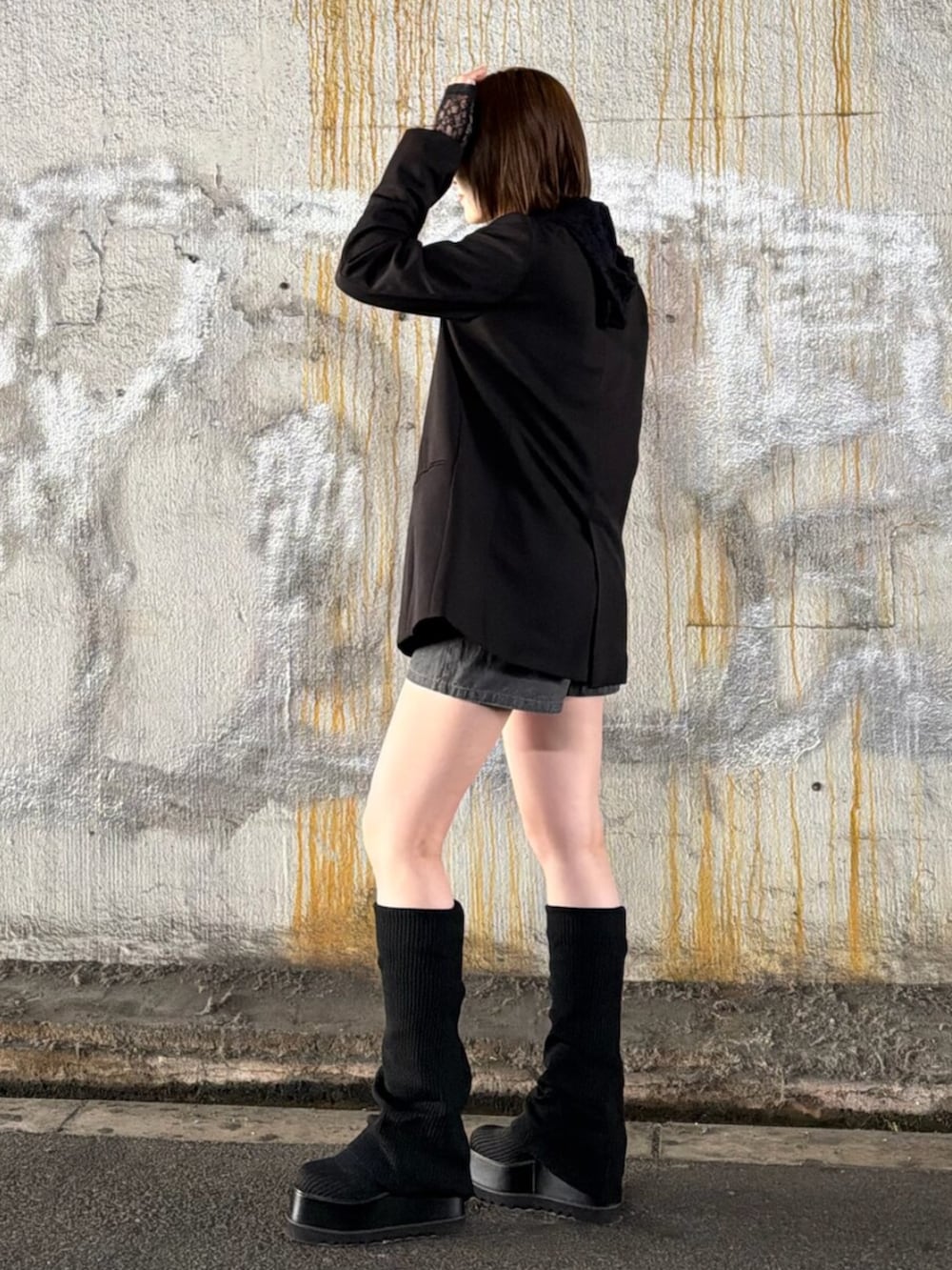 ブラック系のテーラードジャケット、ブラック系のパーカー、ホワイト系のキャミソールを着用したレディースの春コーディネートの4枚目の写真