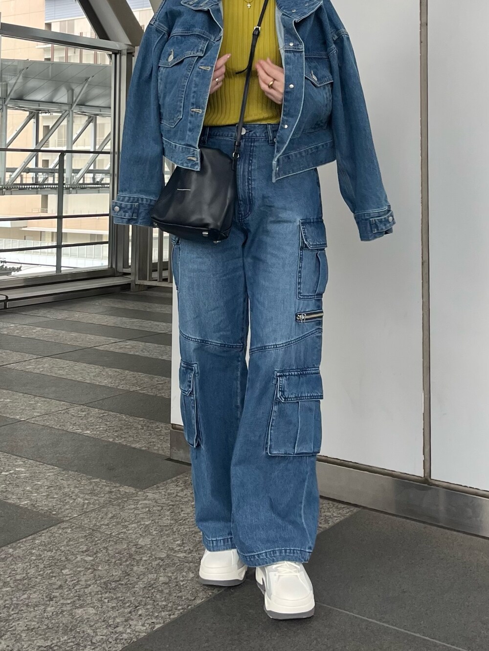 グリーン系のニット/セーター、ブルー系のデニムパンツ、グレー系のスニーカーを着用したレディースの冬コーディネートの6枚目の写真