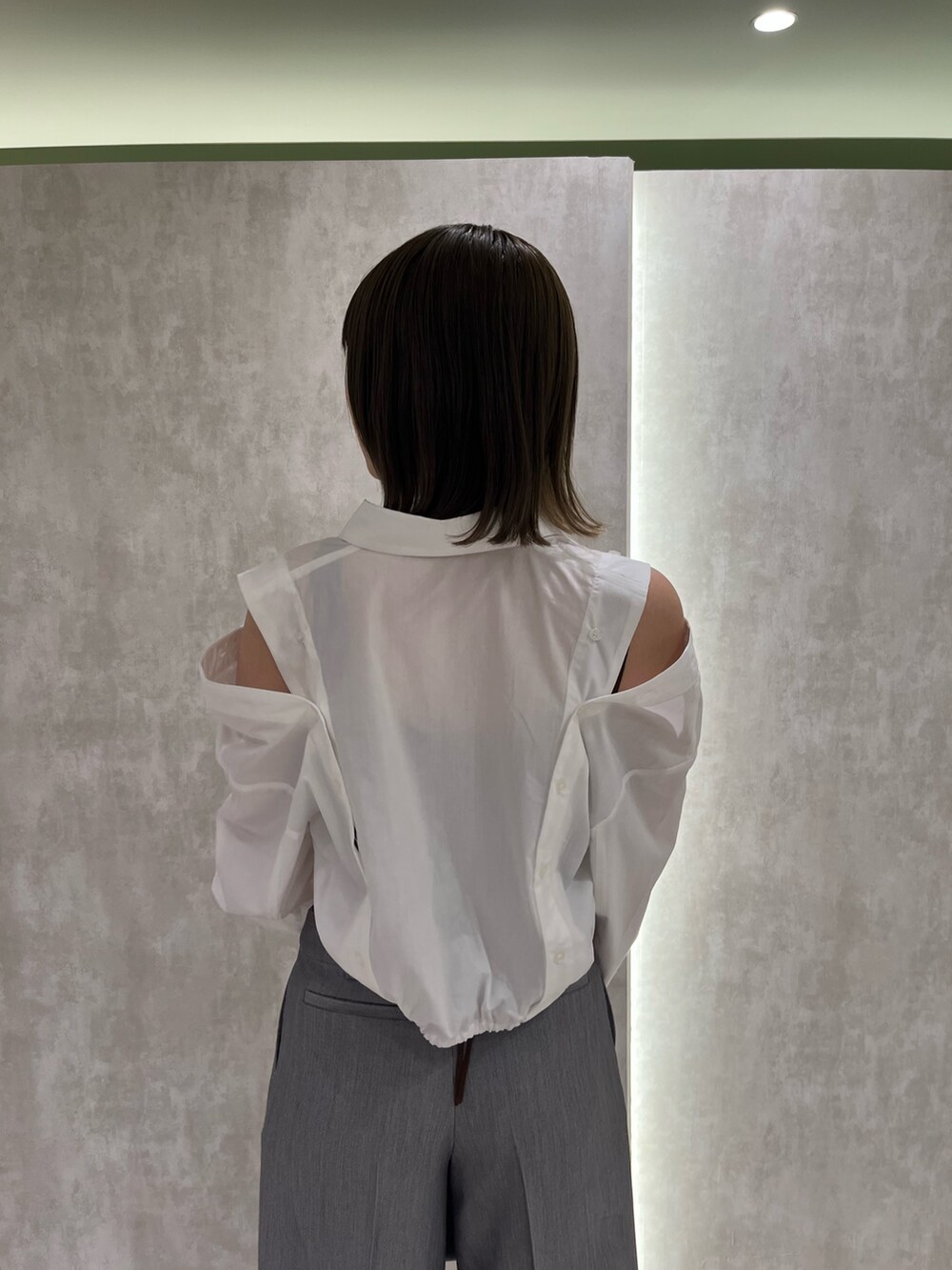 ブラウン系のニット/セーター、ホワイト系のシャツ/ブラウス、ブラック系のサンダルを着用したレディースの春コーディネートの3枚目の写真