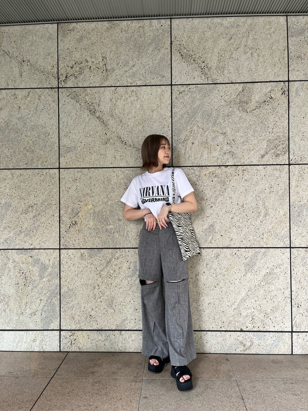 ホワイト系のTシャツ/カットソー、グレー系のスラックス、その他のトートバッグを着用したレディースの夏コーディネートの3枚目の写真