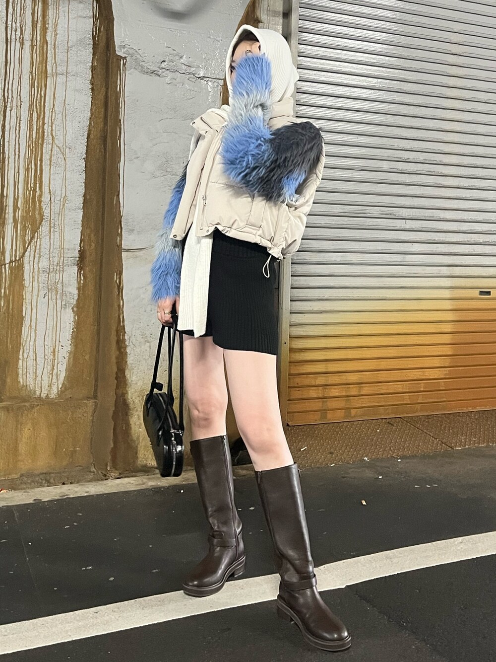 グレー系のニット/セーター、ホワイト系のブルゾン、ブラック系のブーツを着用したレディースの秋コーディネートの3枚目の写真