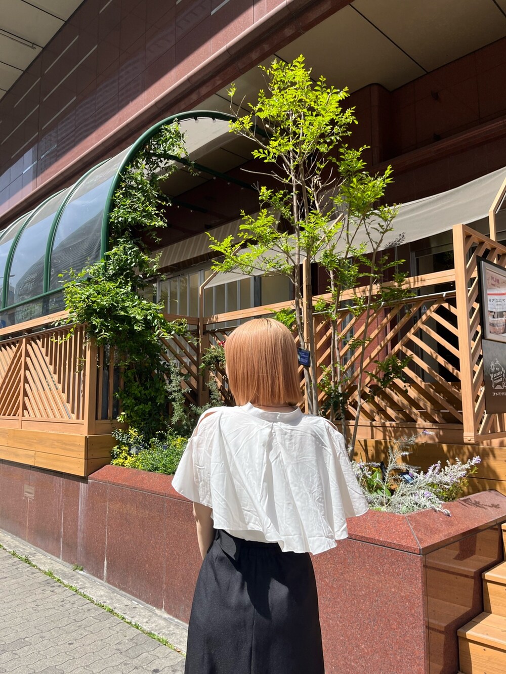 ホワイト系のシャツ/ブラウス、ブラック系のスカート、ブラック系のブーツを着用したレディースの春コーディネートの2枚目の写真