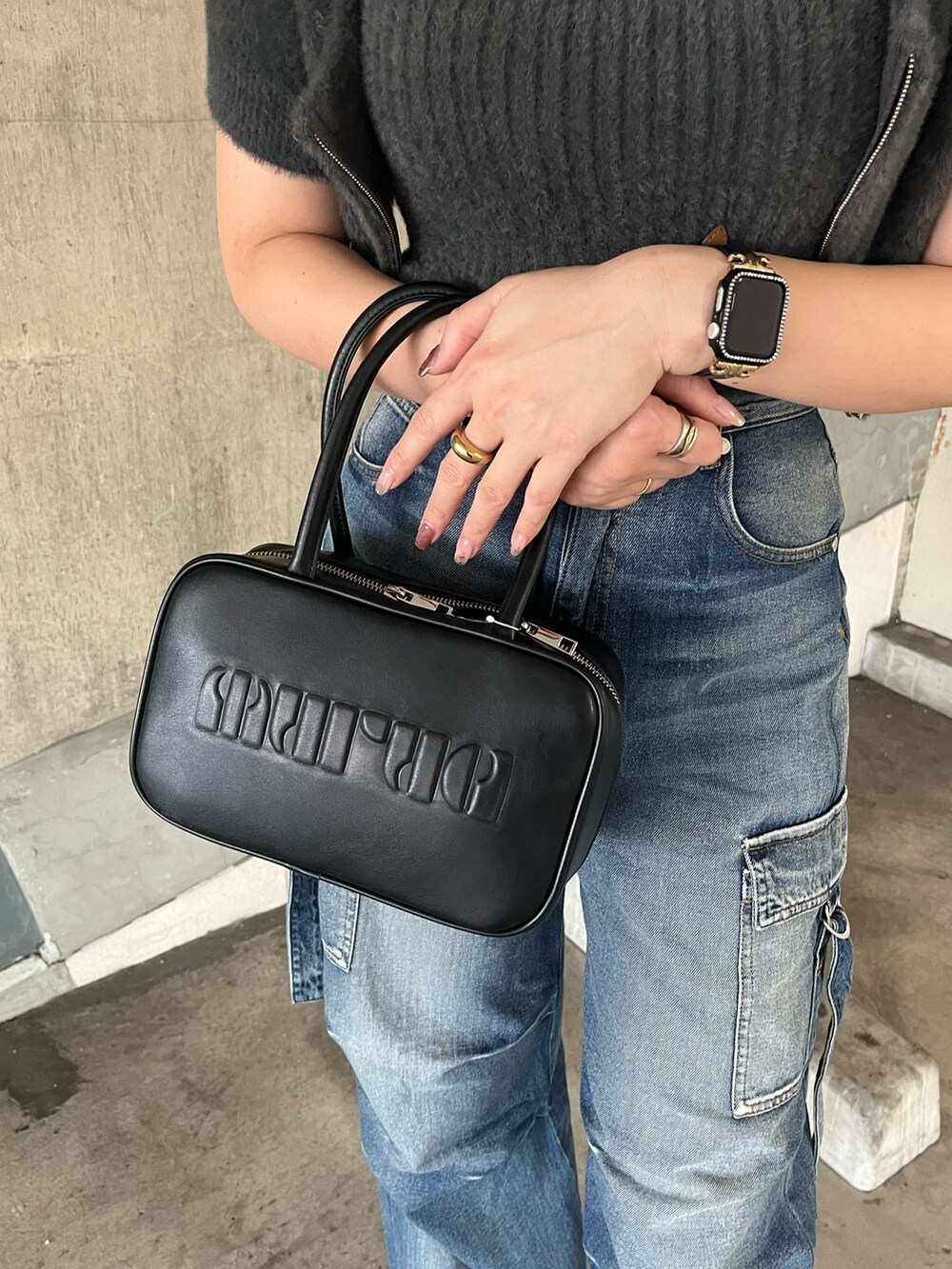 グレー系のニット/セーター、ブルー系のデニムパンツ、ブラック系のパンプスを着用したレディースの秋コーディネートの7枚目の写真