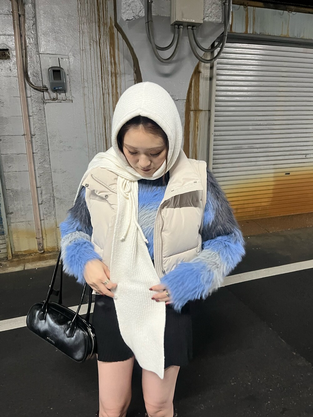 グレー系のニット/セーター、ホワイト系のブルゾン、ブラック系のブーツを着用したレディースの秋コーディネートの5枚目の写真