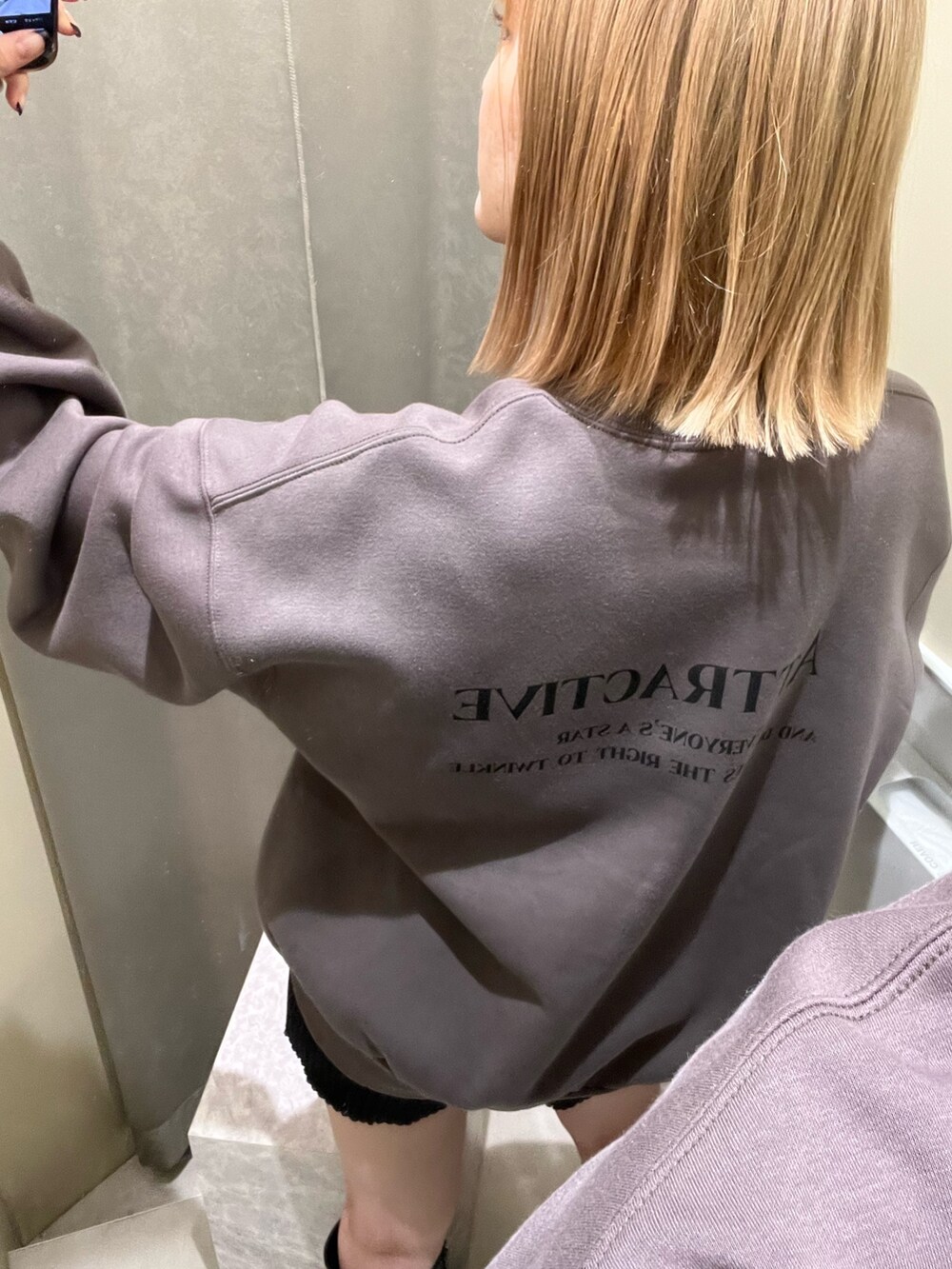グレー系のスウェット、ブラック系のスウェットパンツ、ブラック系のスタジャンを着用したレディースの秋コーディネートの2枚目の写真