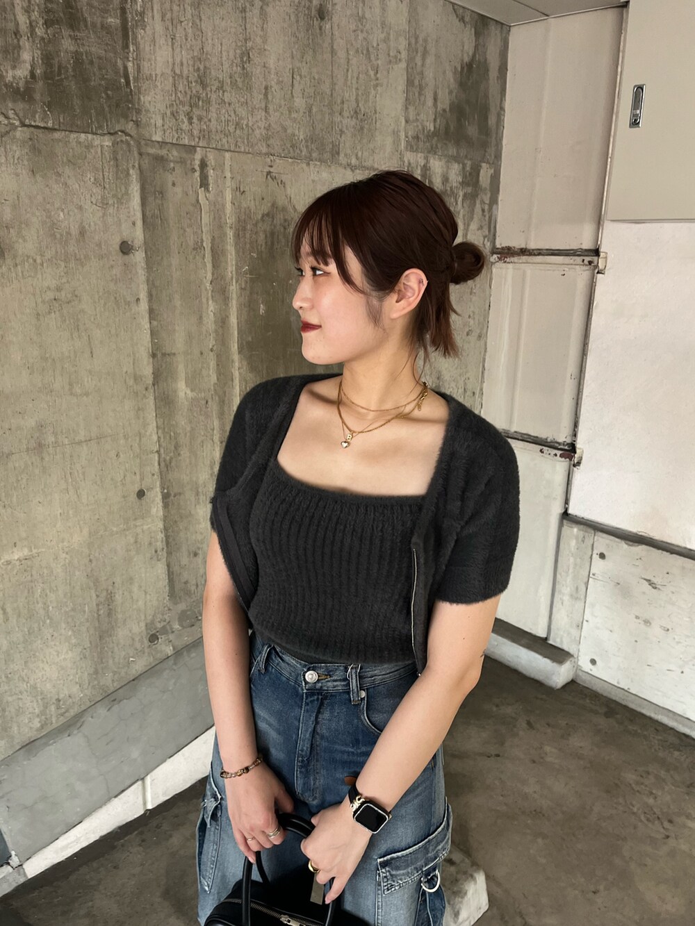 グレー系のニット/セーター、ブルー系のデニムパンツ、ブラック系のパンプスを着用したレディースの秋コーディネートの4枚目の写真